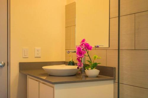 a bathroom with a sink and a flower on a counter at Villa Saltamontes, ocean view and private pool! in Platanillo