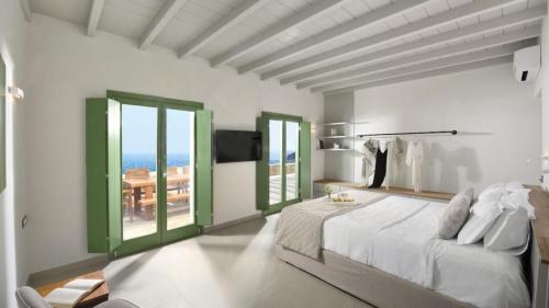 sypialnia z dużym łóżkiem i zielonymi oknami w obiekcie Villa Hermes Mykonos w mieście Mykonos