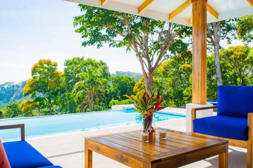 a living room with a table and a swimming pool at Villa Saltamontes, ocean view and private pool! in Platanillo