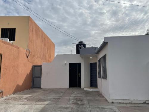 un edificio blanco con una puerta negra. en Cozy studio apartment located in commercial area, en Hermosillo