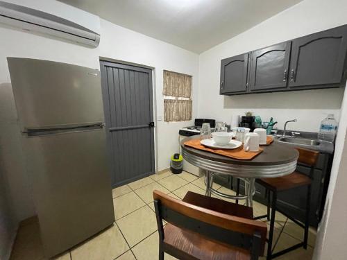 uma cozinha com uma pequena mesa e um frigorífico em Cozy studio apartment located in commercial area em Hermosillo