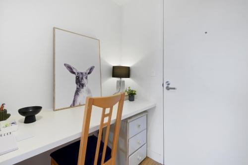 a desk with a chair and a picture of a kangaroo at Cosy 1-Bed with Private Balcony By Showgrounds in Melbourne