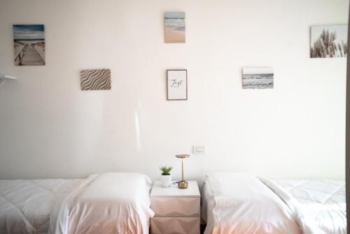 um quarto com duas camas e quadros na parede em Ampio attico con terrazzo con vista, centrale, parcheggio gratis em Milano Marittima