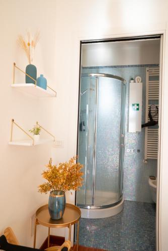 a bathroom with a shower with a vase on a table at Attico panoramico, a pochi passi dal mare, due parcheggi interni inclusi in Milano Marittima