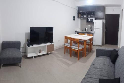 ein Wohnzimmer mit einem Sofa und einem Tisch sowie eine Küche in der Unterkunft Elegante residencia! in Ezeiza
