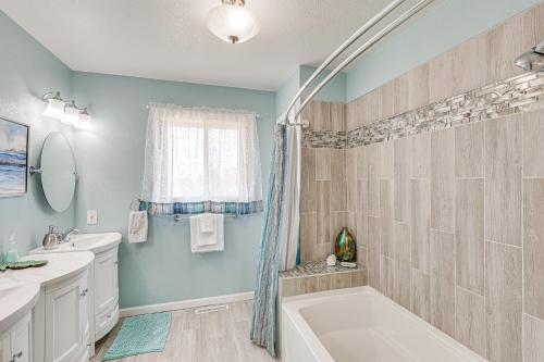 a bathroom with blue walls and a tub and a sink at Scenic and Serene Rapid City Getaway on 1 half Acres! in Rapid City