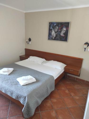 a bedroom with a bed with two towels on it at Garni Hotel Meduza in Rafailovici