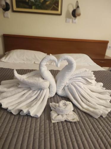 two swans made out of towels on a bed at Garni Hotel Meduza in Rafailovici