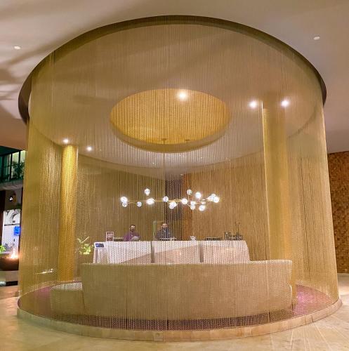 a lobby with a table in a large glass wall at The Fives Downtown Hotel & Residences, Curio Collection by Hilton in Playa del Carmen