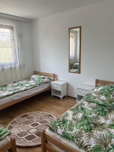 a room with two beds and a mirror at Etno selo Raj na Uvcu in Sjenica