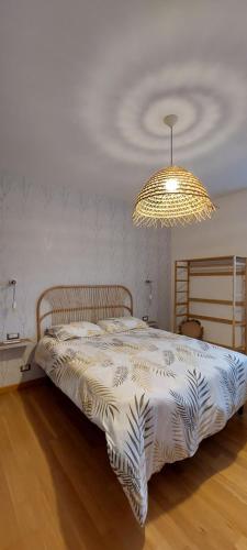 sypialnia z łóżkiem i żyrandolem w obiekcie La Casa di Angela w mieście Montepulciano