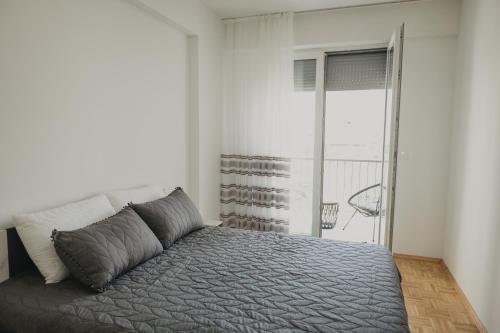 una camera da letto con un letto e una grande finestra di Grozd Apartment a Ohrid