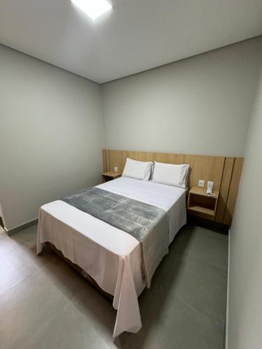 um quarto com uma grande cama branca e 2 almofadas em HS Hotel em São Paulo