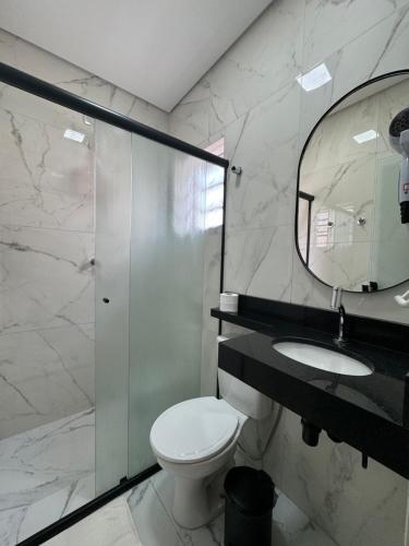 a bathroom with a toilet and a sink and a mirror at HS Hotel in Sao Paulo