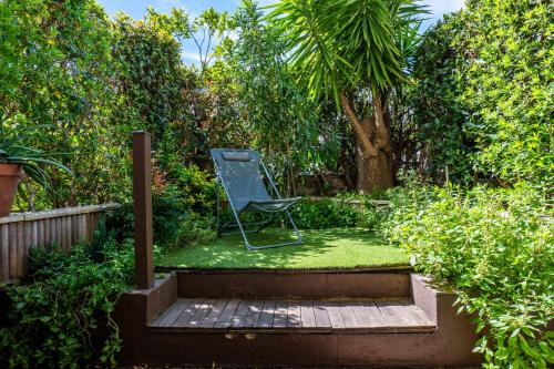 une chaise au milieu d'un jardin dans l'établissement 1-Br Garden-level inside Upscale District, à Cannes