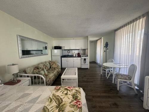 a living room with a couch and a table at Tropical Studios at Marine Surf Waikiki - FREE PARKING - BEST LOCATION - FULL KITCHEN - SWIMMING POOL in Honolulu