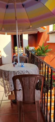 a table with an umbrella on a balcony at Hotel City of Dreams Antigua in Antigua Guatemala