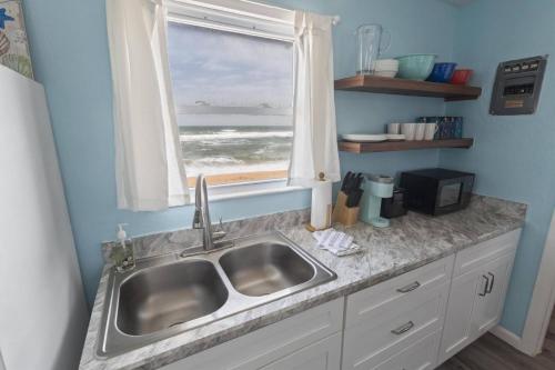 cocina con fregadero y ventana con vistas al océano en Quarter Deck 2 | Flagler Beach | N Ocean Shore Blvd, en Flagler Beach