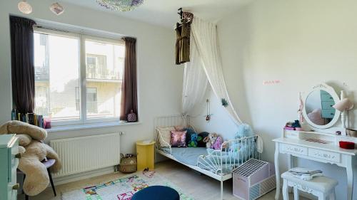 Habitación infantil con cuna y espejo en ApartmentInCopenhagen Apartment 1608, en Copenhague