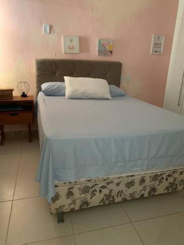 Schlafzimmer mit einem Bett mit einem Kissen und einem Tisch in der Unterkunft Casinha da Paz in Aracaju