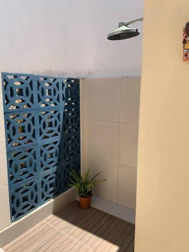 a bathroom with a shower with a blue wall at Casinha da Paz in Aracaju