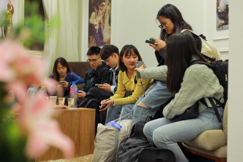 a group of people sitting in a room looking at their cell phones at The Muse Pyramids INN in Cairo