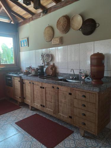 a kitchen with wooden cabinets and a sink and a window at casa rústica e aconchegante in Analândia