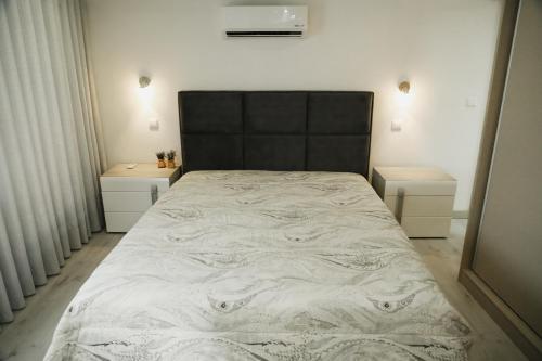 1 cama con cabecero negro y 2 mesitas de noche en Oporto Cruz - Douro Valley, en Baião