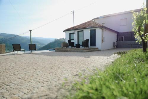 una casa con sillas sentadas fuera de ella en Oporto Cruz - Douro Valley, en Baião