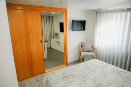 a bedroom with a mirror and a bed and a chair at Oporto Cruz - Douro Valley in Baião