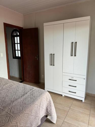 - une chambre avec un lit et une grande armoire blanche dans l'établissement Cantinho do Aconchego, à São Lourenço