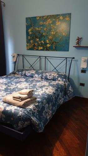 łóżko z niebiesko-białą kołdrą i obrazem w obiekcie A casa di Manu w mieście Isola del Liri