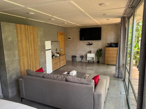a living room with a couch and a tv at Tropicana Beach & Resort in Elwa