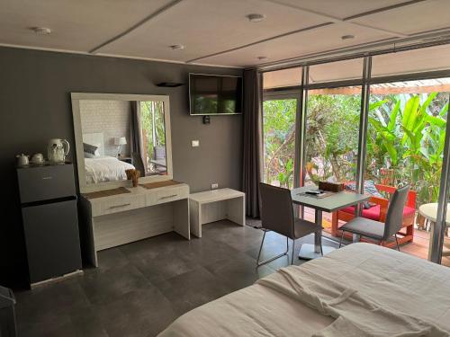 a bedroom with a bed and a table and a mirror at Tropicana Beach & Resort in Elwa