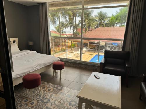 a bedroom with a bed and a view of a pool at Tropicana Beach & Resort in Elwa