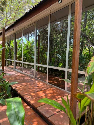 a screened in porch of a house with glass windows at Tropicana Beach & Resort in Elwa