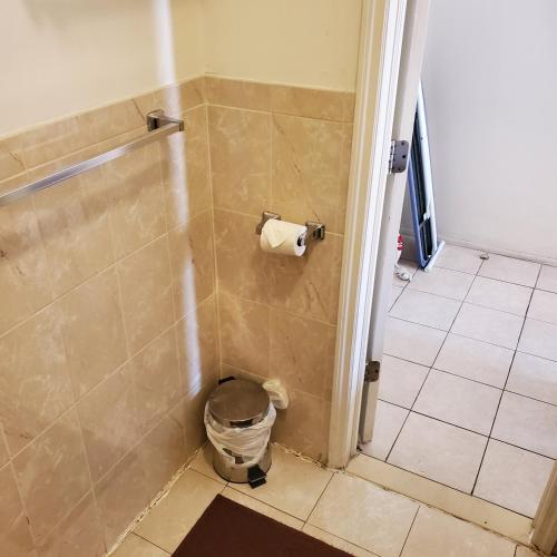 a bathroom with a shower with a toilet paper dispenser at New Studio apartments Available Now!! in Port Morris
