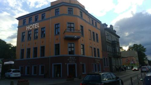 duży pomarańczowy budynek z hotelem przy ulicy w obiekcie Hotel Retro B.A. Zientarski w Zielonej Górze