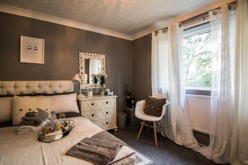a bedroom with a bed and a window and a chair at Oasis in English Village in Crowthorne