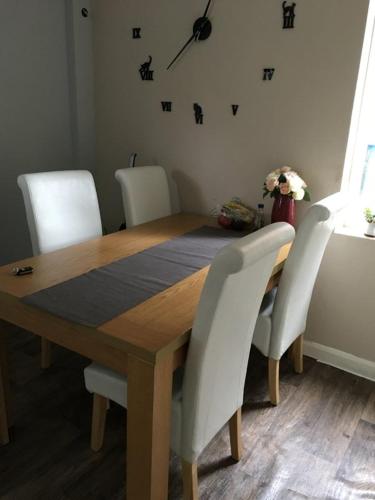 a dining room table with white chairs around it at SOUTHEY HALL ROAD in Sheffield