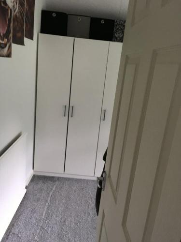 dois armários brancos num quarto com uma porta em SOUTHEY HALL ROAD em Sheffield