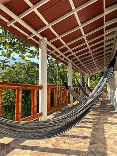 a hammock on the porch of a house at La Veranda Hotel & Restaurant in Minca