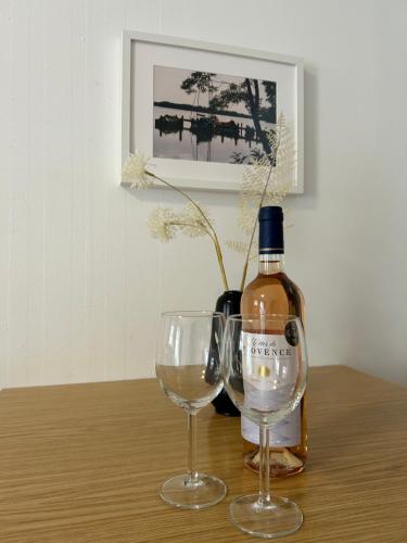 a bottle of wine and two wine glasses on a table at Gemütliche Wohnung Landlust in See-Nähe in Tauche