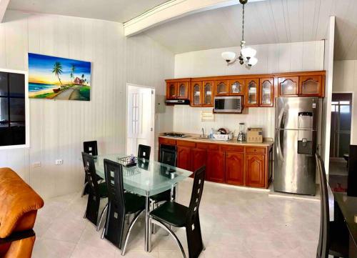 a kitchen with a table and a refrigerator at Casa campestre con piscina y carro in San Andrés