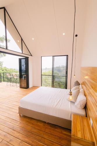 um quarto com uma cama grande e janelas grandes em Glamping MontdeLuxe em Yopal