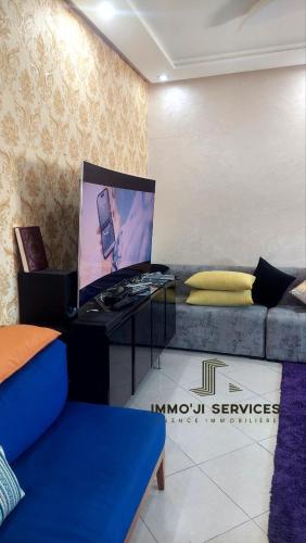 un soggiorno con divano e TV a schermo piatto di azemmour a Azemmour