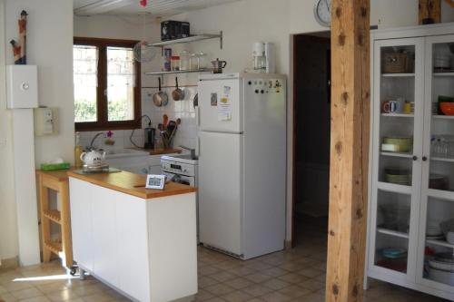 une cuisine avec un réfrigérateur blanc et un comptoir dans l'établissement Maison au coeur du parc naturel de Chartreuse, à Saint-Pierre-de-Chartreuse