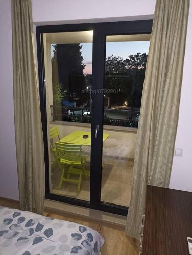 a room with a glass door with a table and a view at Apartament Topalov in Burgas