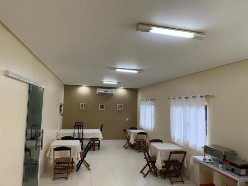 ein Zimmer mit Tischen und Stühlen und ein Zimmer mit Tischen und Stühlen in der Unterkunft PRINCIPE HOTEL in Sorriso
