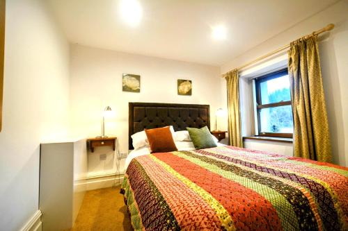 um quarto com uma cama grande e uma janela em Renovated 5 Bedroom Farmhouse in Picturesque Eskdale, Lake District em Eskdale